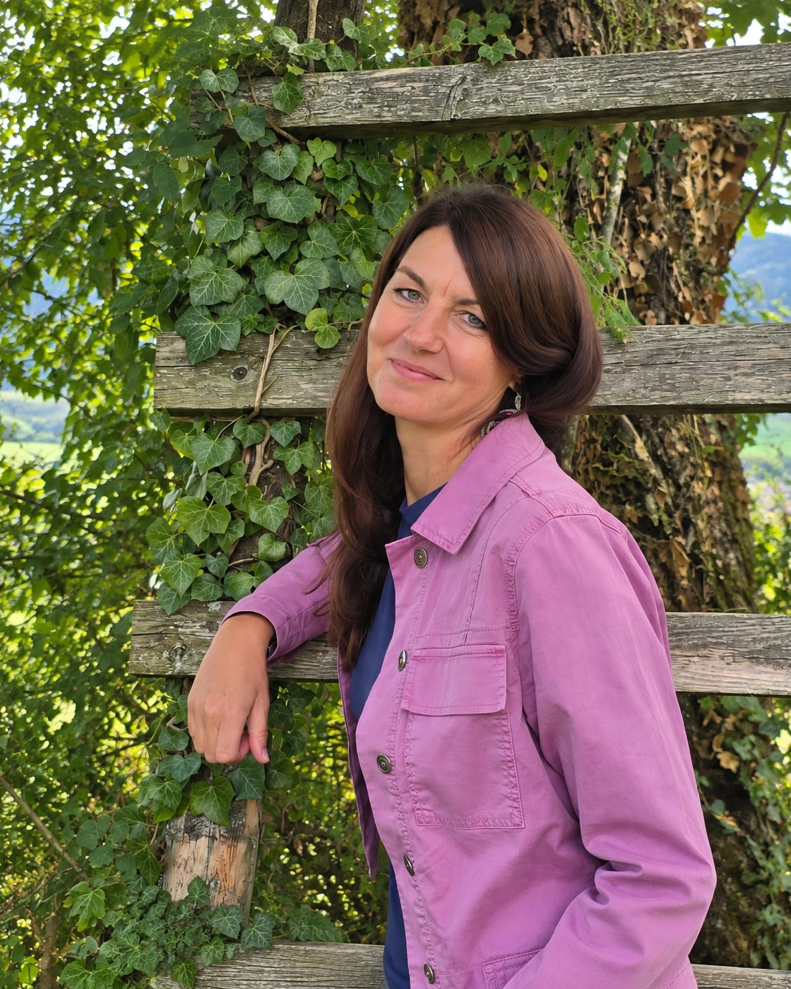 Michaela Schachner vor einer natürlichen Holzfassade